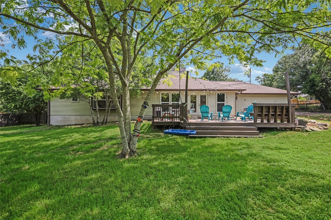 6802 Rio Bravo Lane Austin, TX 78737 - Photo 15 of 18 Rear view of house featuring a yard and a wooden deck