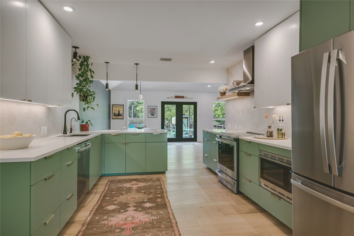 6802 Rio Bravo Lane Austin, TX 78737 - Photo 6 of 18 Kitchen with green cabinetry, backsplash, stainless steel appliances, modern cabinets, and recessed lighting