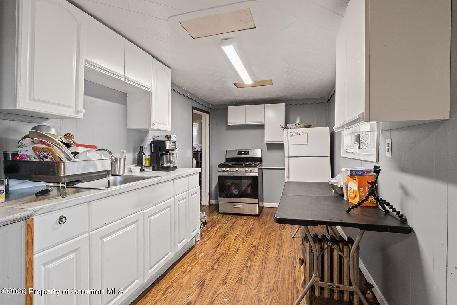 1406 North Main Avenue Scranton, PA 18508 - Photo 7 of 29 a kitchen with stainless steel appliances a stove a sink a refrigerator and cabinets