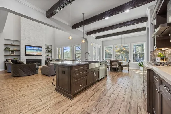 a dining room with wooden floor a chandelier a wooden table and chairs