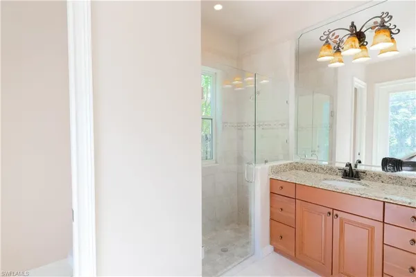 a bathroom with a granite countertop sink a toilet and shower
