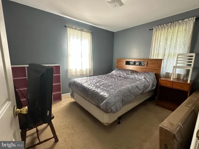 a bedroom with a bed chair and window