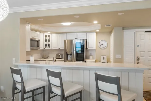 a kitchen with stainless steel appliances kitchen island granite countertop a stove a refrigerator a kitchen island a table and chairs in it