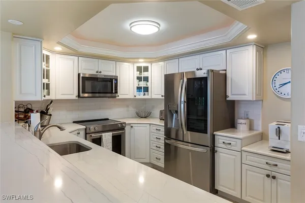 a kitchen with stainless steel appliances a refrigerator stove microwave and sink