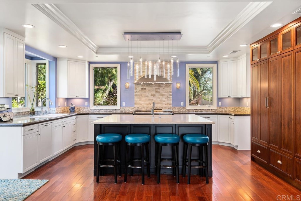 1620 Bella Vista Drive Encinitas, CA 92024 - Photo 8 of 35 a kitchen with stainless steel appliances granite countertop wooden floors and wooden cabinets