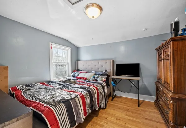 a bedroom with a bed and a flat screen tv