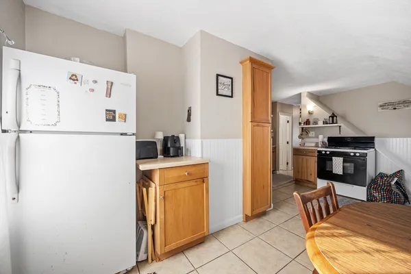 a white refrigerator freezer and a stove sitting inside of a kitchen