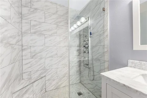 a bathroom with a sink shower and a mirror