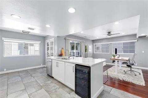 a view of a kitchen counter top space with sink wooden floor and furniture