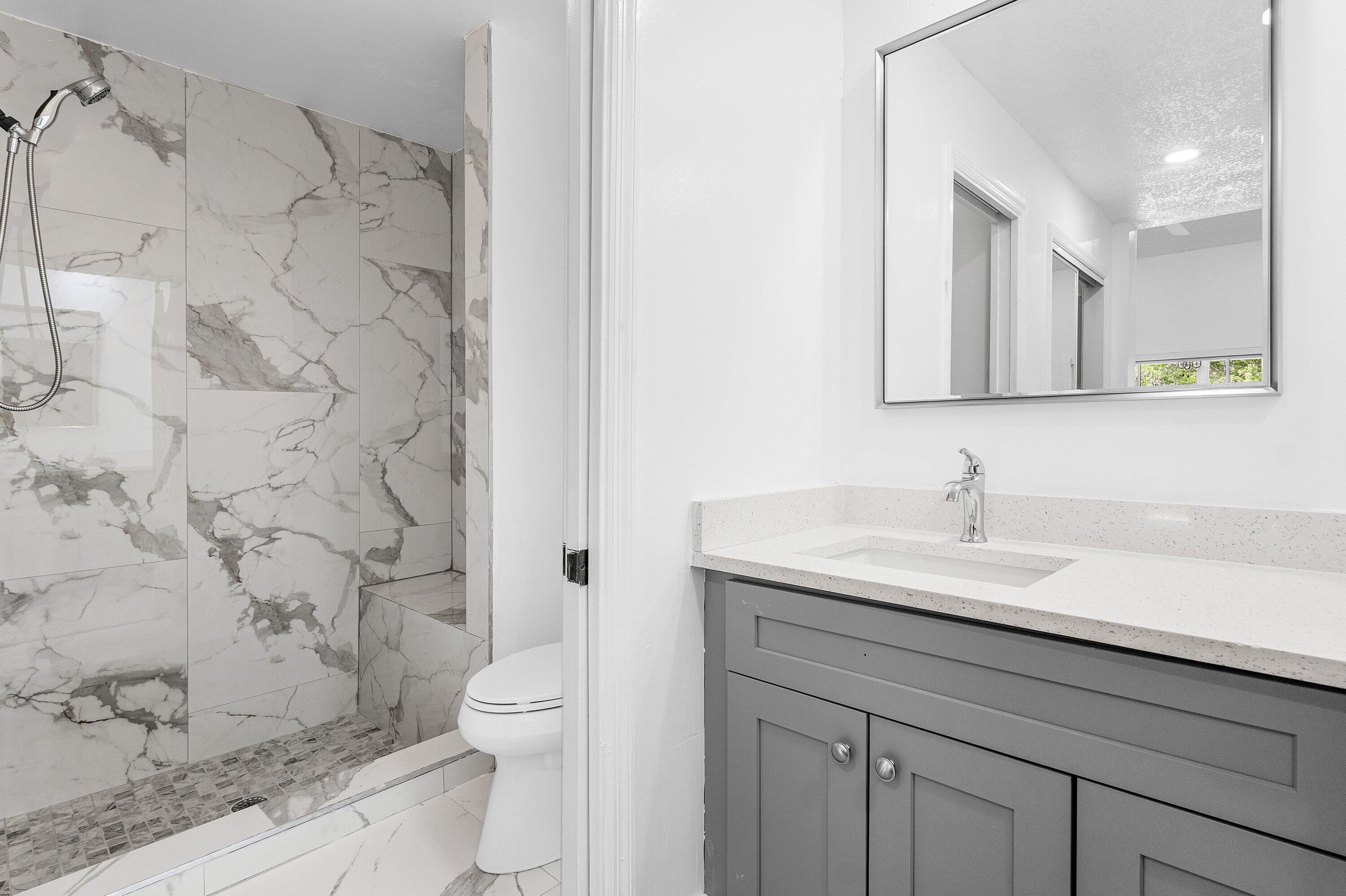 11163 180th Court South Boca Raton, FL 33498 - Photo 13 of 22 a bathroom with a granite countertop sink a toilet and a shower