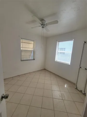 an empty room with a ceiling fan and carpet