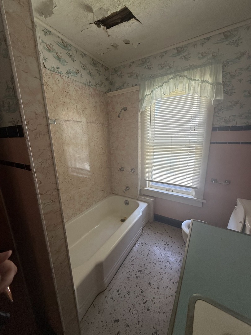 503 East Main Street Morrison, IL 61270 - Photo 16 of 42 a bathroom with a tub a sink and a window