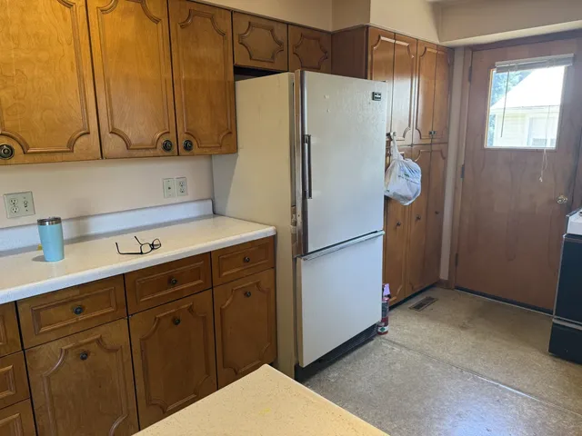a kitchen with a refrigerator sink and cabinets