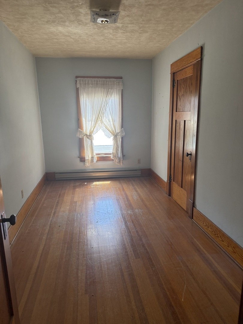 503 East Main Street Morrison, IL 61270 - Photo 9 of 42 an empty room with wooden floor and windows