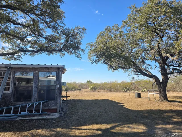 a view of a yard with wooden fence