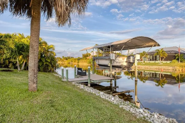 a view of a lake with a yard and large trees