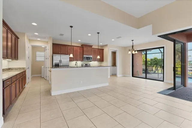 a kitchen with kitchen island wooden cabinets stainless steel appliances and a window