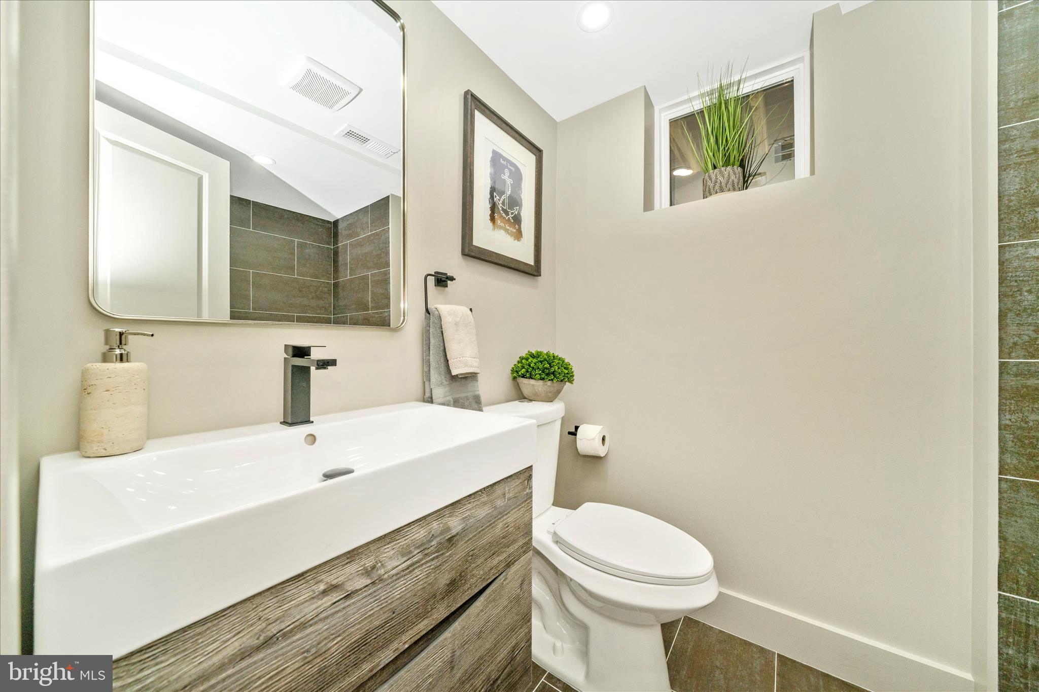 10405 Inwood Avenue Silver Spring, MD 20902 - Photo 33 of 52 a bathroom with a sink a toilet and mirror