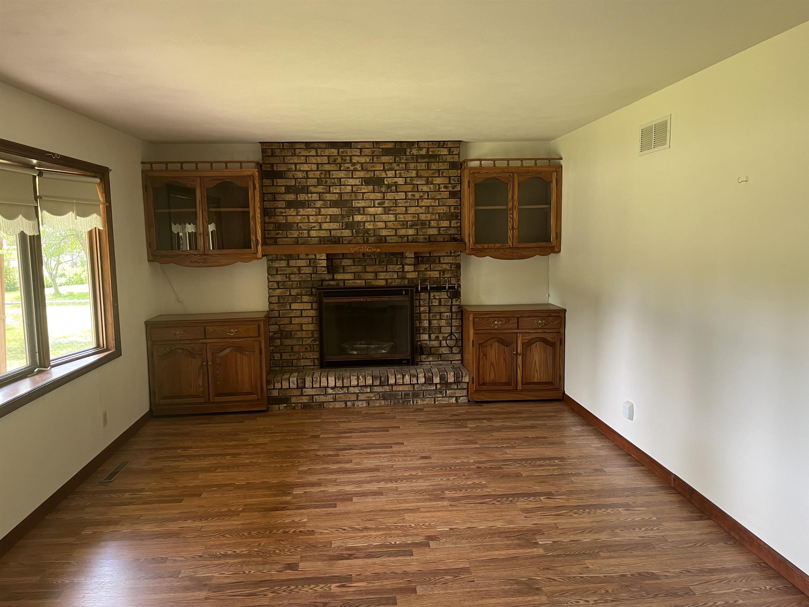 6816 Stardust Trail Roscoe, IL 61073 - Photo 4 of 21 a view of an empty room with a fireplace and a window
