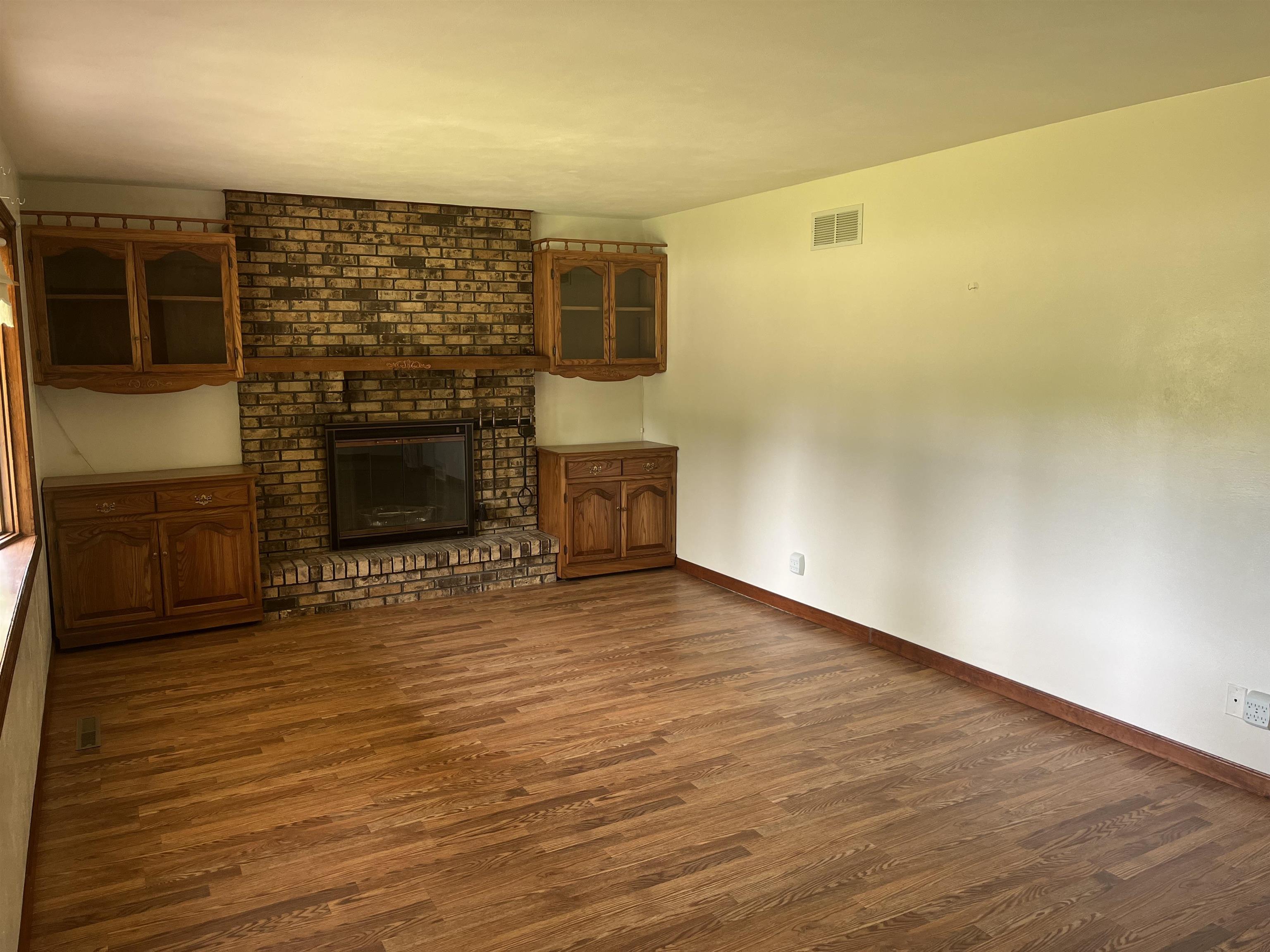 6816 Stardust Trail Roscoe, IL 61073 - Photo 5 of 21 a view of empty room with wooden floor and fireplace