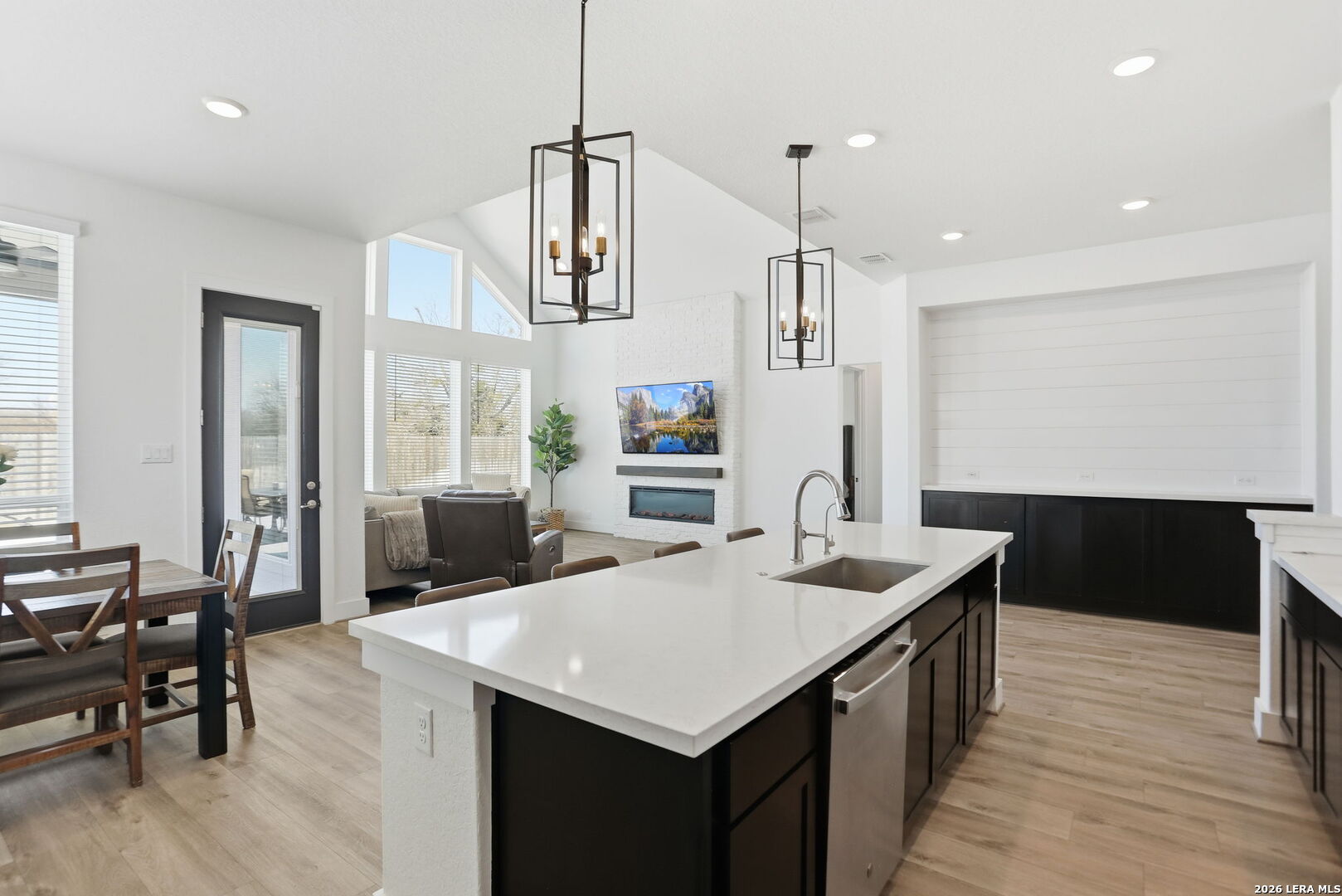 405 Corwin Cibolo, TX 78108 - Photo 17 of 46 a kitchen with a stove a refrigerator a sink a dining table and chairs with wooden floor