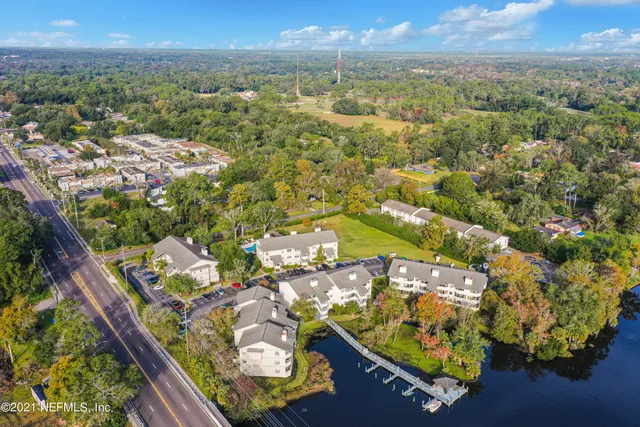 an aerial view of residential house with outdoor space and trees all around