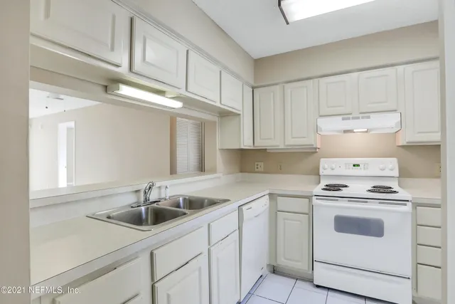 a kitchen with white cabinets sink and white appliances