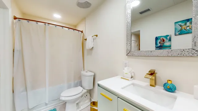 a bathroom with a sink a toilet and a shower curtain