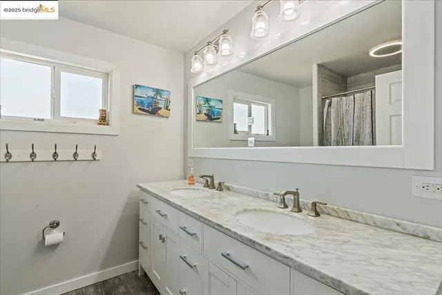 a bathroom with a granite countertop sink and a mirror