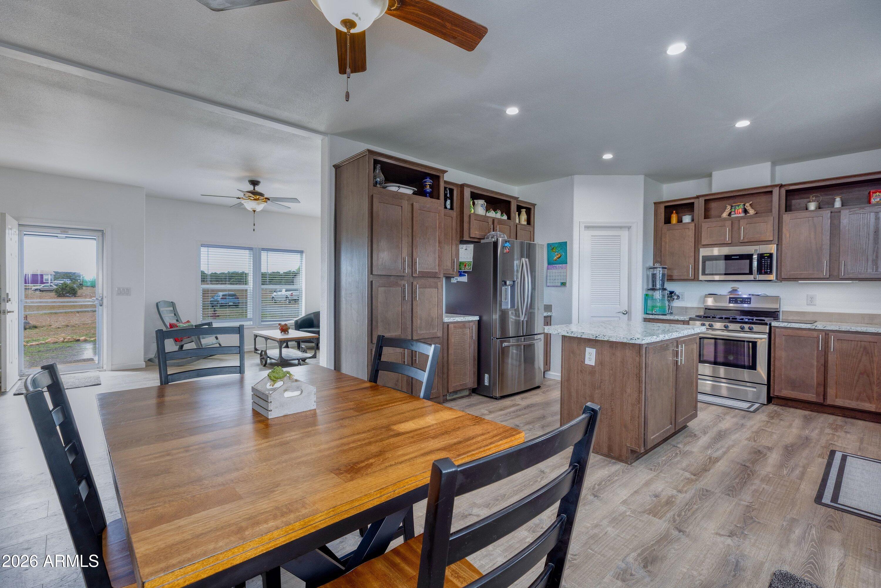 6644 Avanti Way Show Low, AZ 85901 - Photo 11 of 29 a kitchen with stainless steel appliances granite countertop a sink a stove a dining table and chairs