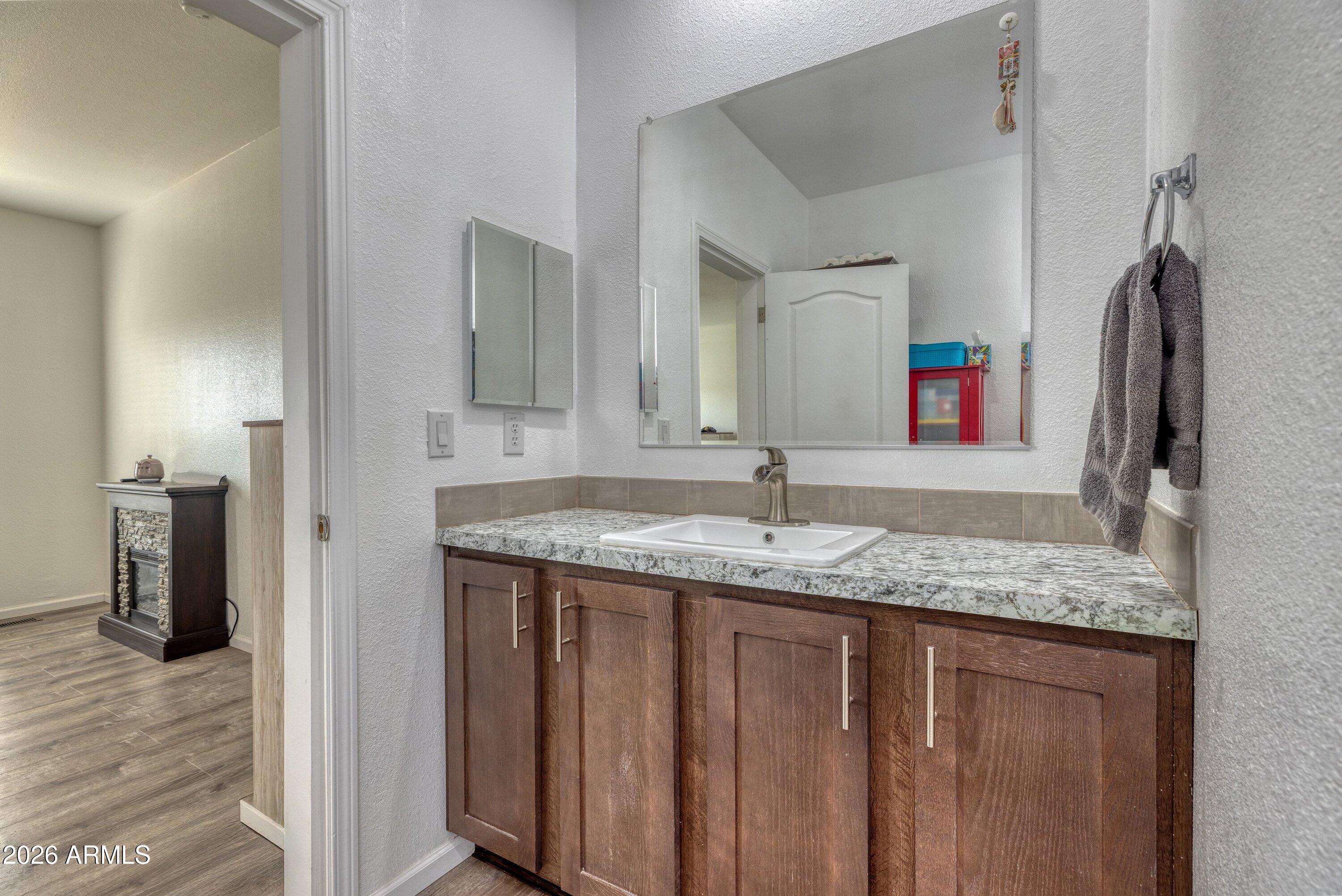 6644 Avanti Way Show Low, AZ 85901 - Photo 15 of 29 a bathroom with a granite countertop sink and a mirror