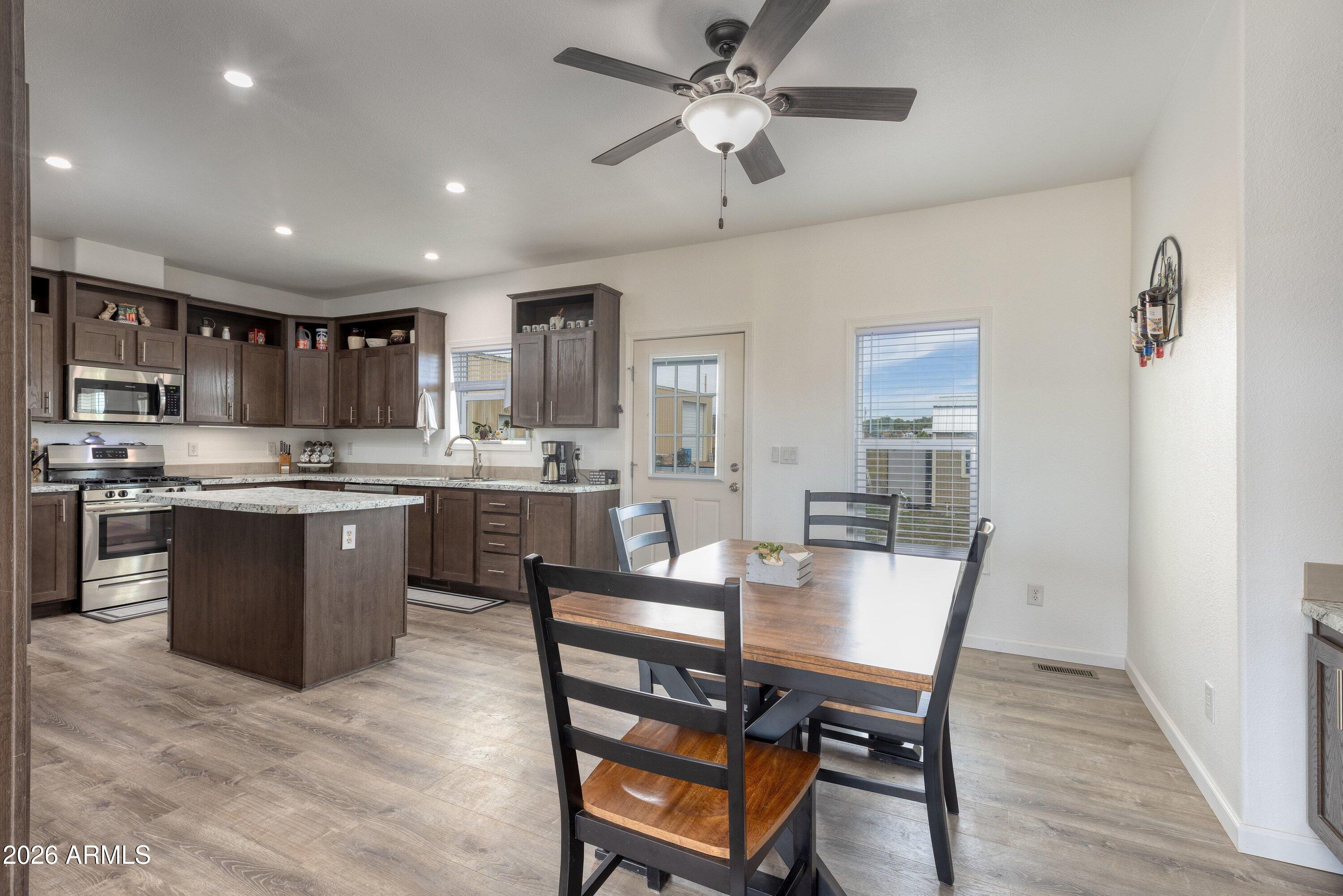 6644 Avanti Way Show Low, AZ 85901 - Photo 8 of 29 a kitchen with a dining table chairs and refrigerator