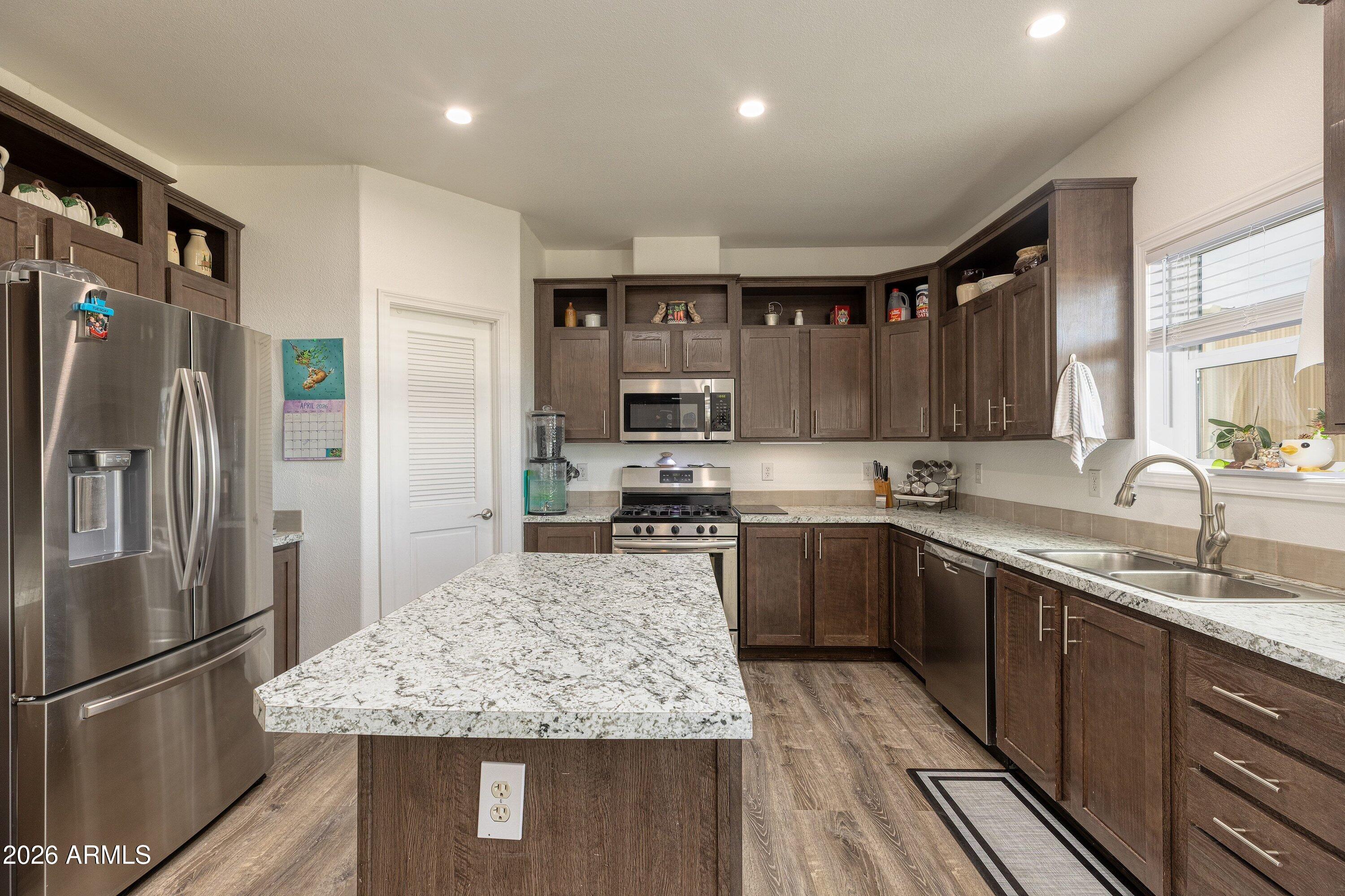 6644 Avanti Way Show Low, AZ 85901 - Photo 9 of 29 a kitchen with stainless steel appliances granite countertop a refrigerator stove sink and cabinets
