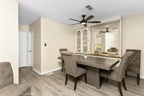 a dining room with furniture a chandelier and wooden floor