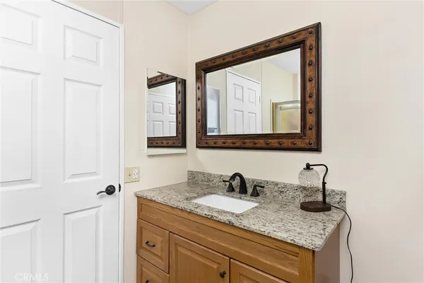 a bathroom with a granite countertop sink and a mirror