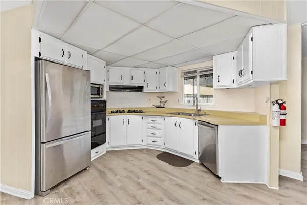 a kitchen with granite countertop stainless steel appliances a refrigerator a sink and cabinets