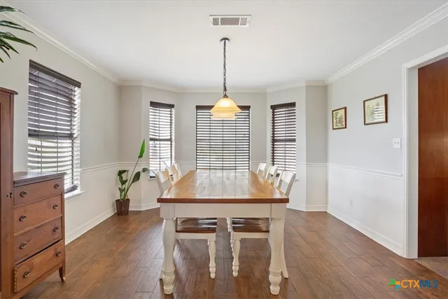 a dining room with furniture window and wooden floor