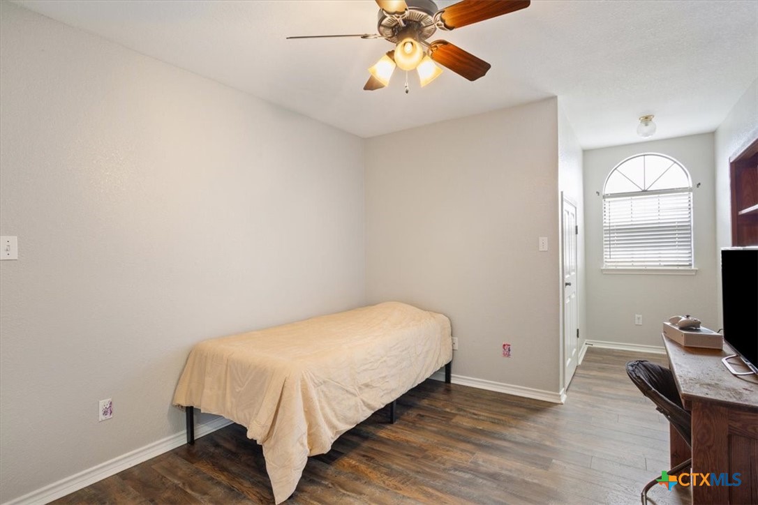 8600 Five Wells Road Rogers, TX 76569 - Photo 26 of 47 a bedroom with a bed and a chandelier