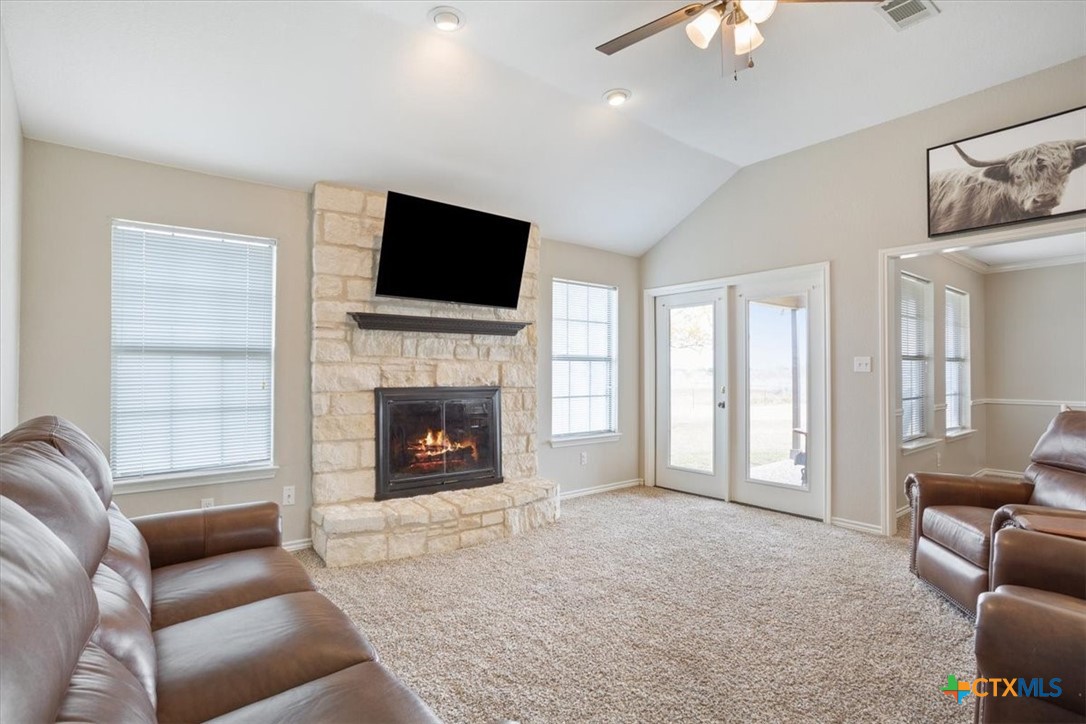 8600 Five Wells Road Rogers, TX 76569 - Photo 33 of 47 a living room with furniture a fireplace and a flat screen tv