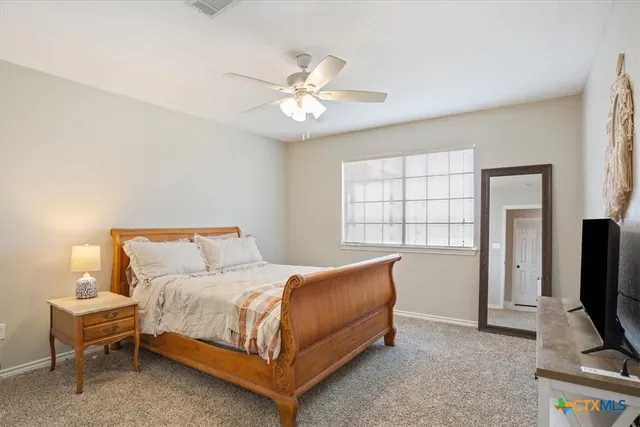 a bedroom with a bed and a tv on the dresser