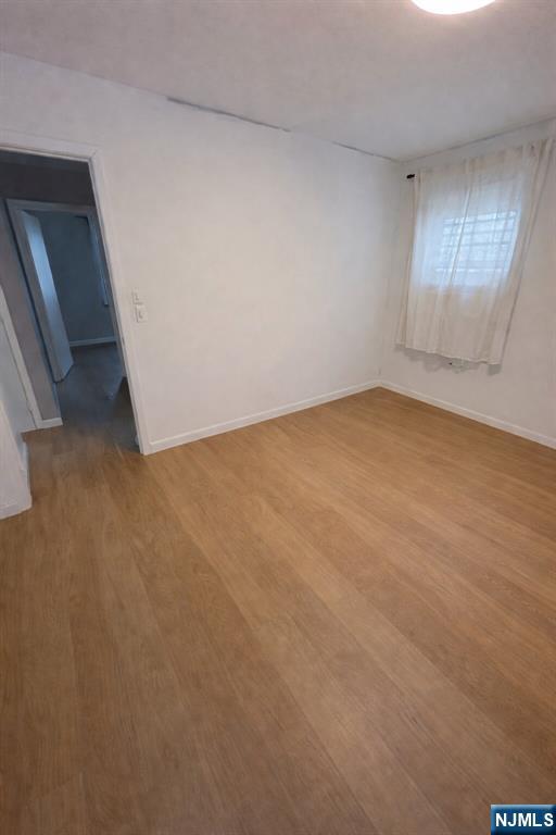 122 Dean Drive, Unit 1 Tenafly, NJ 07670 - Photo 12 of 15 an empty room with wooden floor and windows