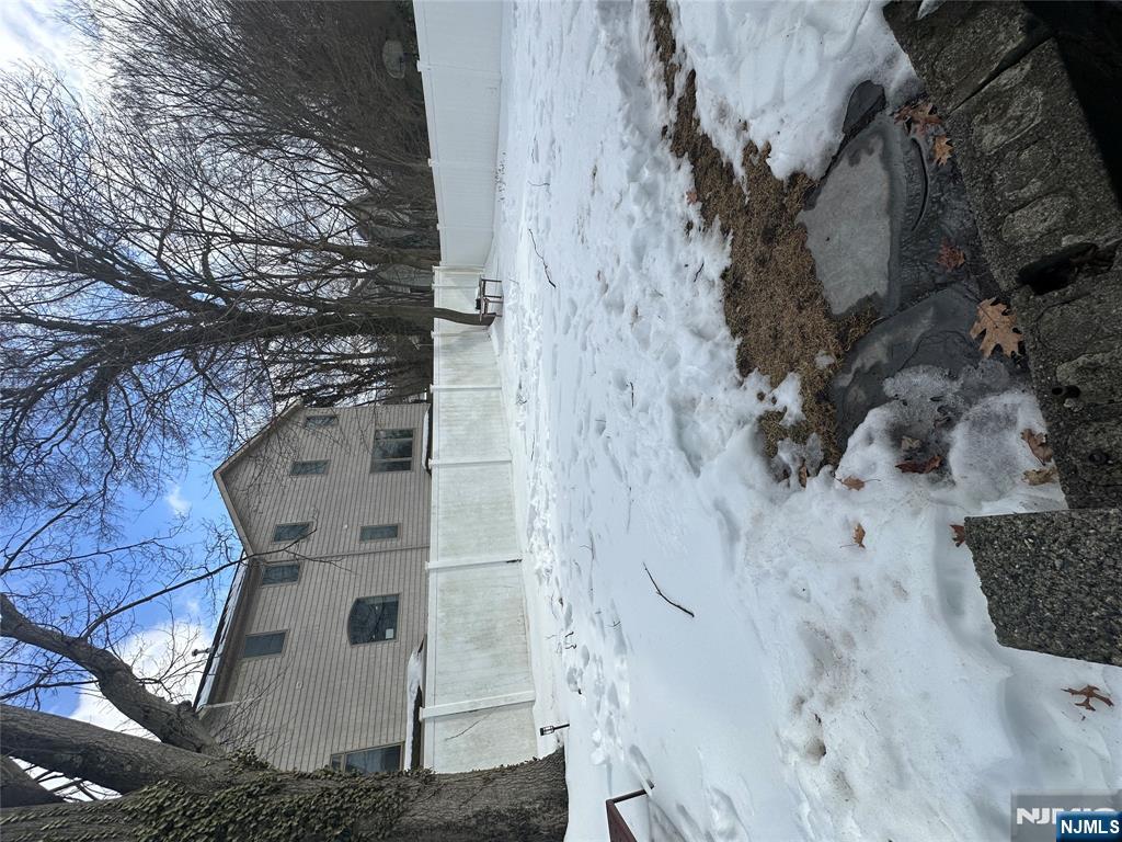 122 Dean Drive, Unit 1 Tenafly, NJ 07670 - Photo 15 of 15 a front view of a house with a yard covered with snow