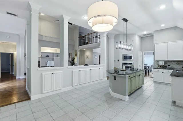 a kitchen with stainless steel appliances a stove a sink and white cabinets