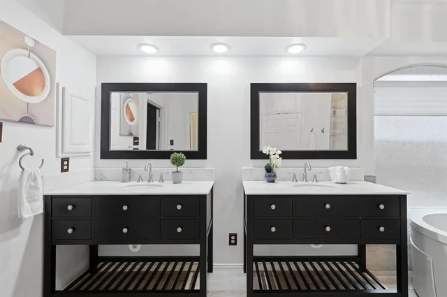 a bathroom with double vanity sinks and a mirror