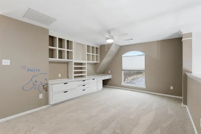 an empty room with windows and cabinet