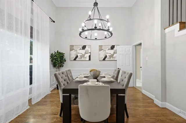 a dining room with furniture a potted plant and wooden floor