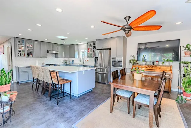 a kitchen with a refrigerator a dining table and chairs