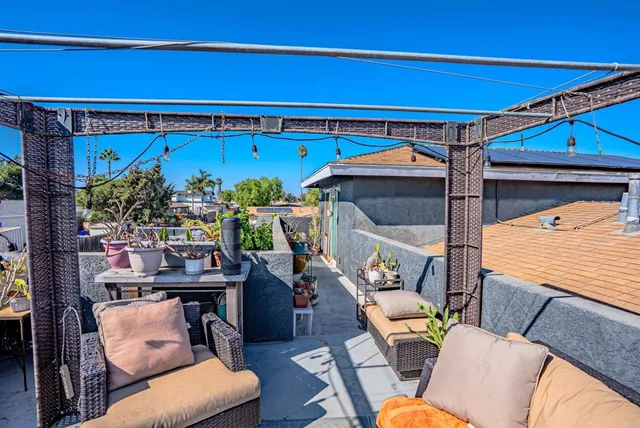 a view of a balcony with chairs and potted plants