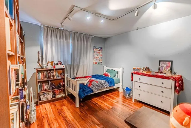 a bedroom with a bed and a book shelf