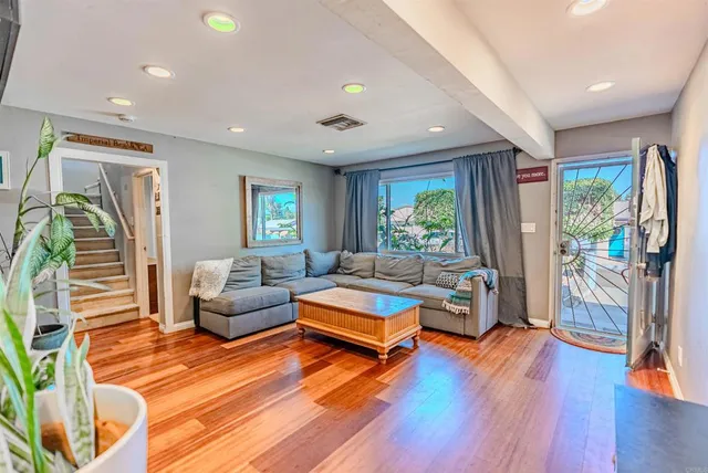 a living room with furniture and a wooden floor